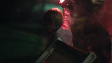 Child playing with sparkler. Young boy celebrating rite of passage during 4th of july celebration party