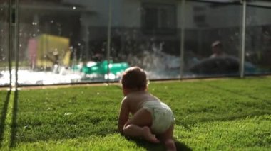 Yüzme havuzunun içinde oynayan çocuklara bakıyorum.