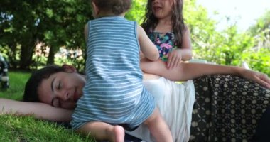 Anne ara veriyor, çocuklar annelerinin uykudan uyanmasını istiyor.