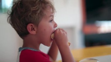 Küçük çocuk sabah kahvaltısında ellerinle krep yiyor.