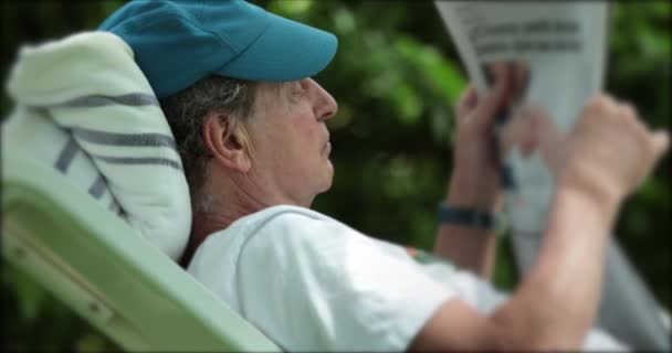 Candid Senior Man Reading News While Lying Relaxing Enjoying Retirement — 图库视频影像