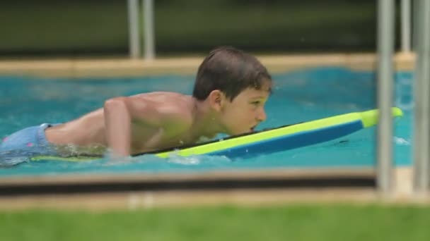 小男孩在冲浪板顶上的游泳池里玩耍 — 图库视频影像