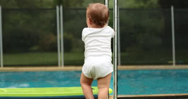 Baby Leaning Swimming Pool Fence Security Infant Foreground While Kids — 图库视频影像