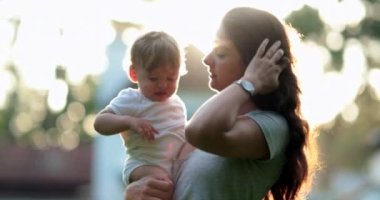 Candid mom holding baby infant during sunset, woman scratching nose and face allergy