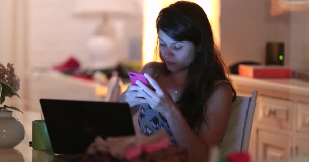 Gece Geç Saatte Bir Kadın Cep Telefonunu Laptop Ekranını Kontrol — Stok video