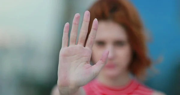 Woman holding hand in denial rejecting, saying STOP