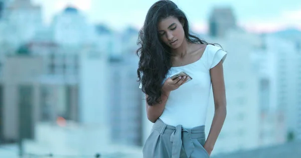 Young african black woman looking at cellphone screen in city