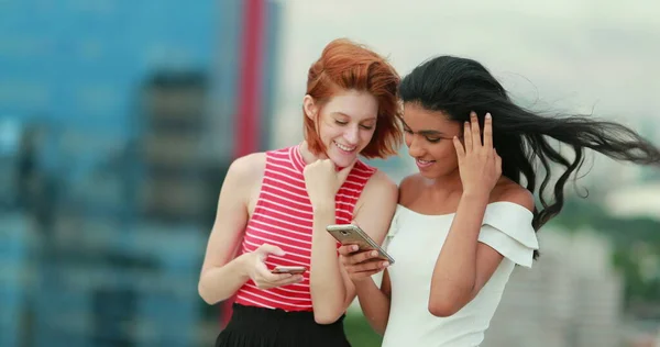 若い多人種の女性の友人は スマートフォンを保持し メディアコンテンツをチェックオンライン笑いと笑顔 率直な — ストック写真