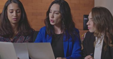 Dizüstü bilgisayarın önünde çalışan genç bayan çalışanlara iş sonuçlarını açıklayan yönetici patron. İnsanlar geceleri modern teknoloji bilgisayarının önünde kurumsal ofis çalışma alanında çalışıyorlar. İş tartışan kadınlar