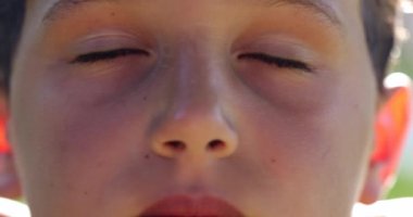 Genç çocuk meditasyonda derin bir nefes alıyor. Çocuk gözlerini açıyor, makro çocuk gözleri nefes alıyor.