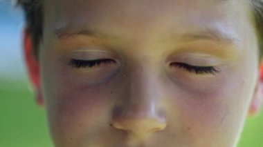 Meditative young boy child closing eyes. Kid close-up face looking to camera portrait eye