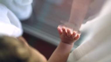 Bebek bebek pencereye yaslanıyor ve eli dışarı çıkmak istiyor.