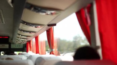 Passenger POV in the back of bus traveling on road trip