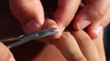 Trimming hand nail close-up. Parent cutting child finger nails