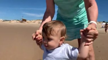Baby walking at beach shore for first time