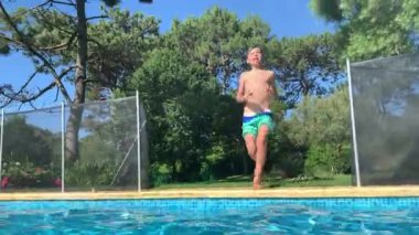 Çocuk koşuyor ve havuz suyuna dalıyor.