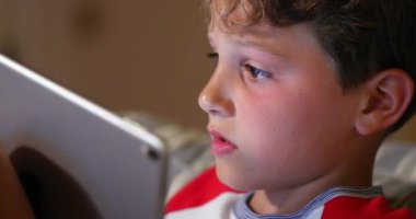 Genç çocuk tablet teknolojisiyle online oyun oynuyor. Yarışmada çocuk video oyunu bağımlılığı. Teknolojinin yerli nesli