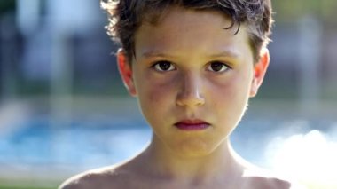 Portrait of young boy smiling to camera. Child face close-up outside in sunlight looking to camera