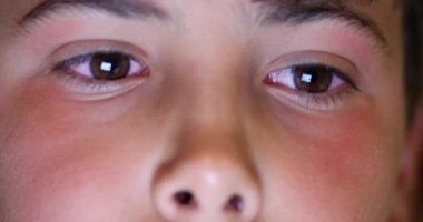 Child boy face macro eyes looking at tablet device screen at night, kid browsing internet online