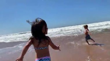 Sahilde koşan küçük kız çocuğu.