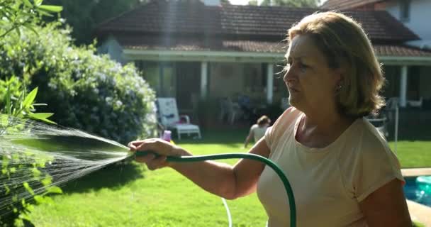 Older Woman Gardening Water Plants Water Hose Sunlight — Video Stock