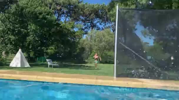 Kind Läuft Heimischen Garten Und Springt Ins Schwimmbadwasser — Stockvideo