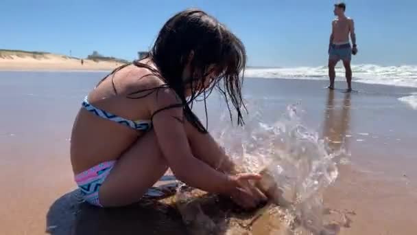 子供女の子シンク足で砂でビーチ遊びで海岸 — ストック動画