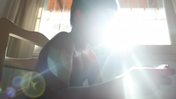 男孩和控制器一起玩网络游戏 镜头闪烁着光芒穿过窗户 — 图库视频影像