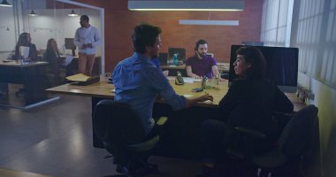 Geceleri ofis içi işyerinde çalışan insanlar. Birlikte çalışma alanındaki yoğun çalışanların iç mekanları. Şirket işadamları ve iş kadınları masalarında oturuyor ve iş yerinde yürüyorlar. Ofis hayatı fazla mesai