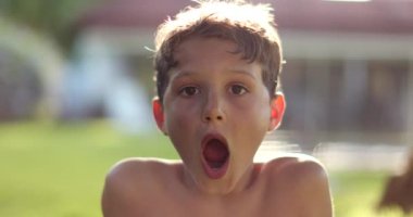 Young boy astonished surprise SHOCK reaction. Child reacting to news, exaggerated expression