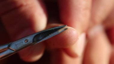 Mother clipping trimming child nails finger closeup