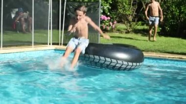 İki çocuk koşuyor ve havuz suyuna dalıyor.