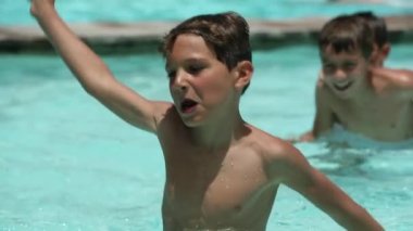 Genç çocuk yüzme havuzunda topla rekabetçi oyun oynuyor