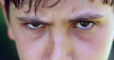 Upset young boy portrait. Child frowning to camera in macro close-up