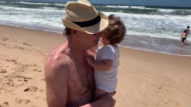 Grandfather Holding Baby Grandson Beach — Stockvideo