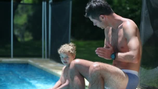 外のプールで一緒にお父さんと息子 子供に水泳を教える親 — ストック動画