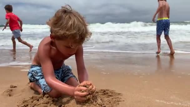 Bambino Che Cerca Costruire Castello Sabbia Onda Oceanica Che Arriva — Video Stock