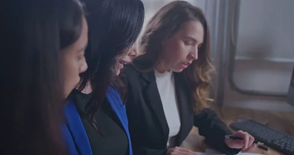 Office female leader explaining work to young employees. Businesswoman coaching work to millennial staff. Female senior executive showing graphs and documents to work colleagues