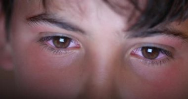 Genç erkek makro gözler ekran cihazına bakıyor