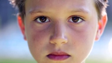 Handsome young boy portrait outdoors. Child looking to camera outside smiling