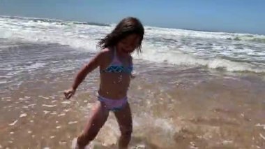 Little girl child playing at beach, kid running at sea shore