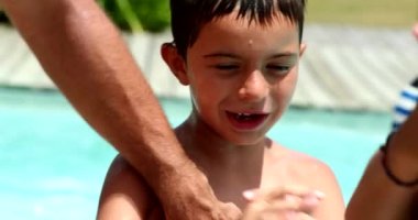 Ebeveyn, çocuk vücuduna güneş kremi sürüyor. Erkek teninin korunması için güneş kremi sürüyorum