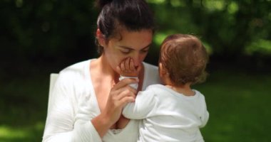 Anne parkta bebeğe sarılıyor ve onu seviyor.