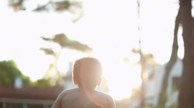 Happy boy jumping in the air raising arms and fist in celebration. Child celebrating achievement feeling joy
