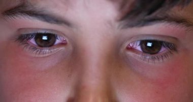 Çocuk makro gözler geceleri ekran cihazına bakıyor. Çocuk çocuk oyun oynuyor