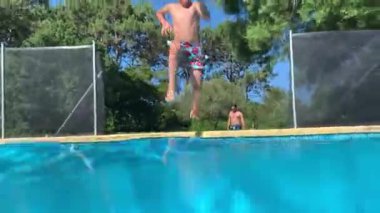 Mutlu çocuk yaz tatilinde yüzme havuzuna atlayıp koşuyor.