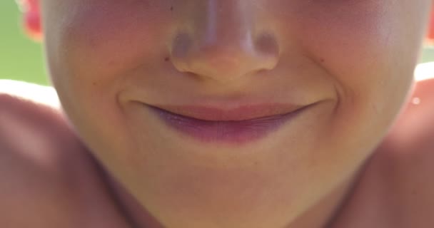 若い男の子の唇を閉じて笑みを浮かべて 幸せな子供の口はカメラに笑顔 — ストック動画