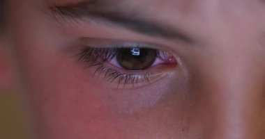 Macro closeup of child boy staring at tablet screen. Boy looking at blue light glowing