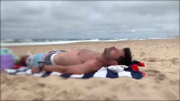 Чоловік Відпочиває Пляжі Відпочиваючи Людина Заснула Березі Моря — стокове відео