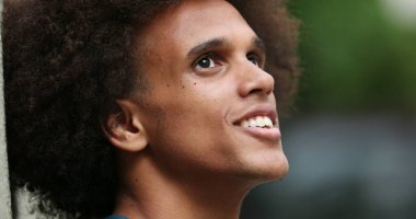 Contemplative happy young african man candid